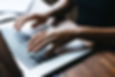 Hands typing on laptop.